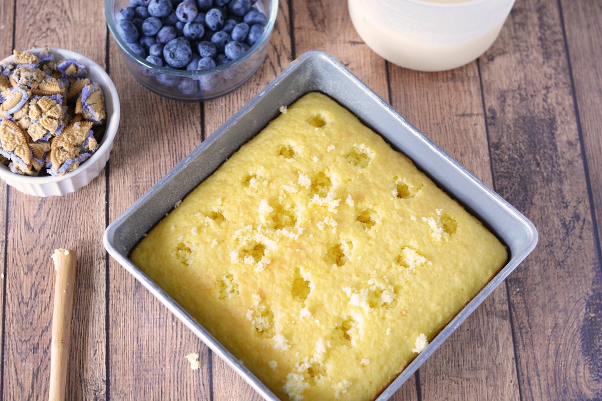 Poke holes into cake with the handle of a wooden spoon