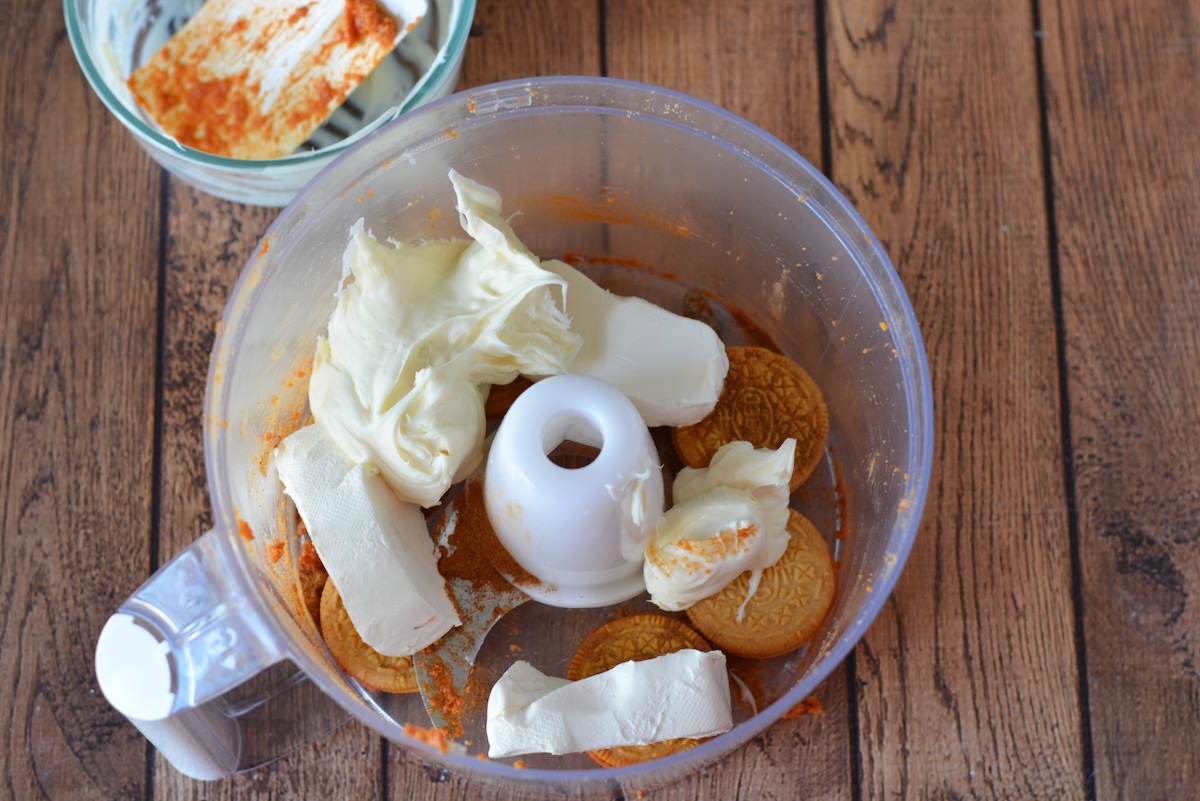 Cream cheese, white chocolate, and pumpkin oreos in a food processor