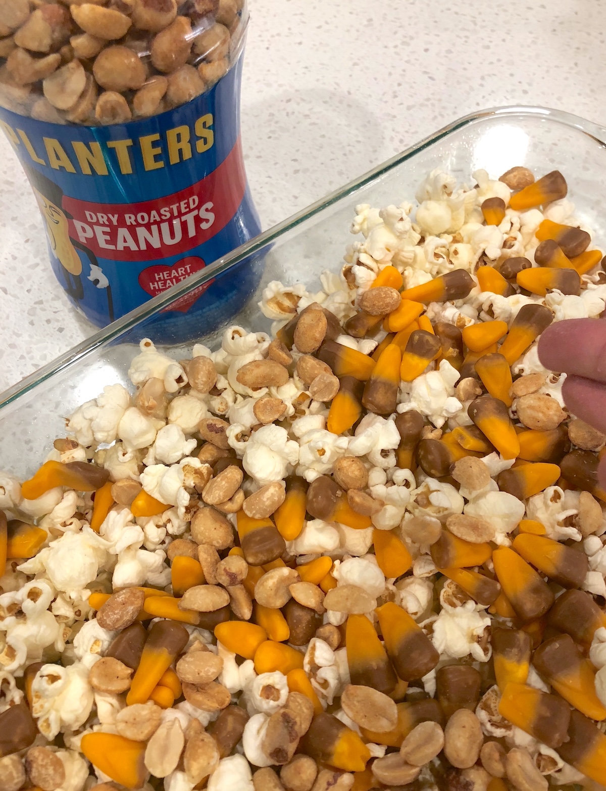 Pour peanuts on top of the popcorn