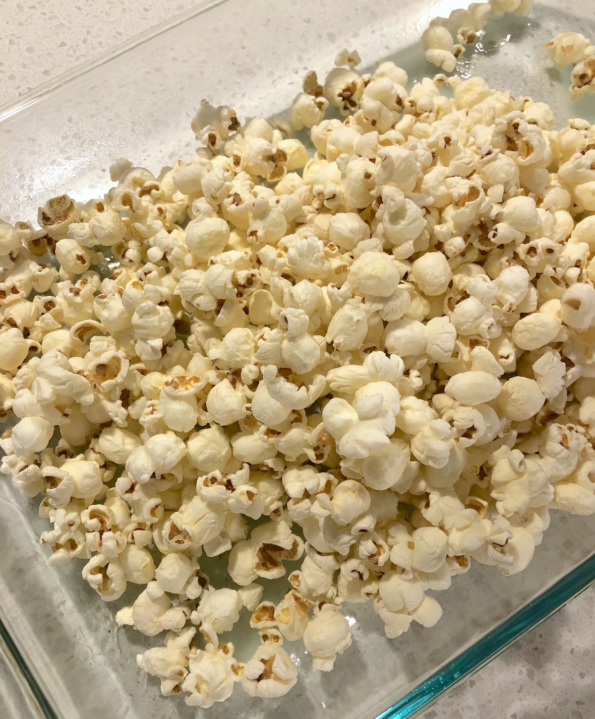 Pour popcorn into a glass casserole dish