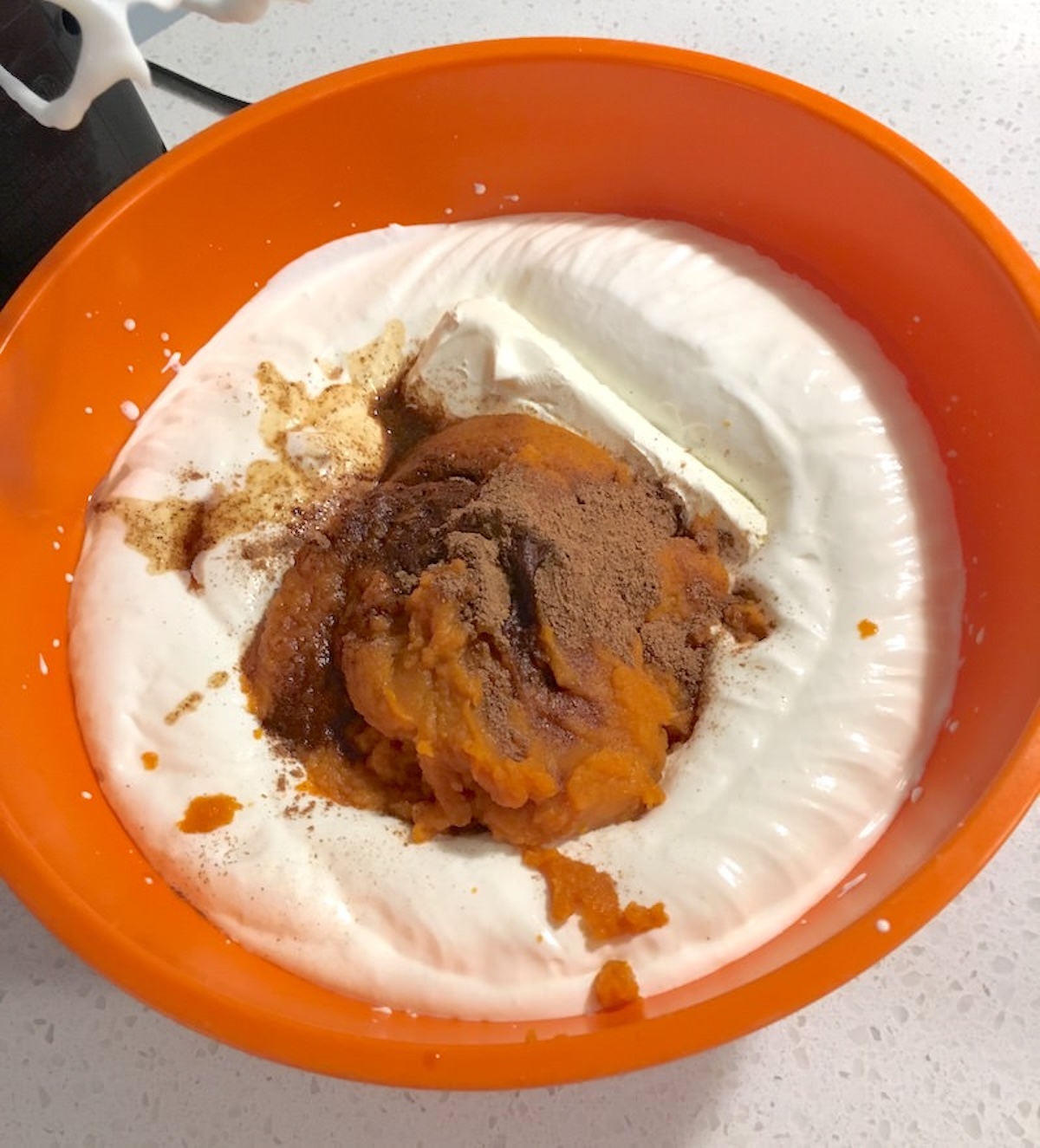 Pumpkin puree added to the whipped cream