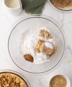 flour, brown sugar, cinnamon, baking powder, and baking soda together in a clear glass bowl