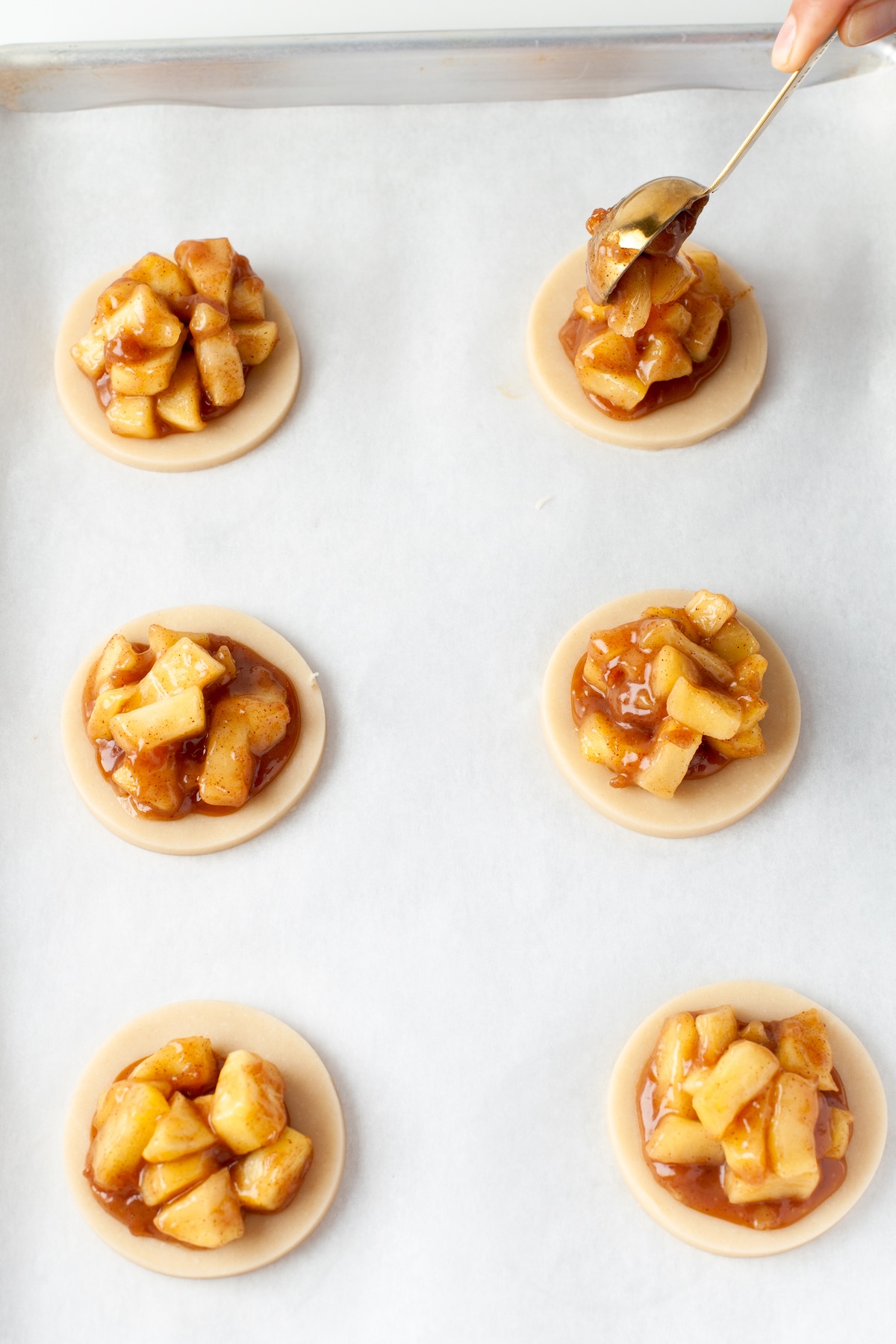 Adding the apple mixture on top of the caramel and the dough