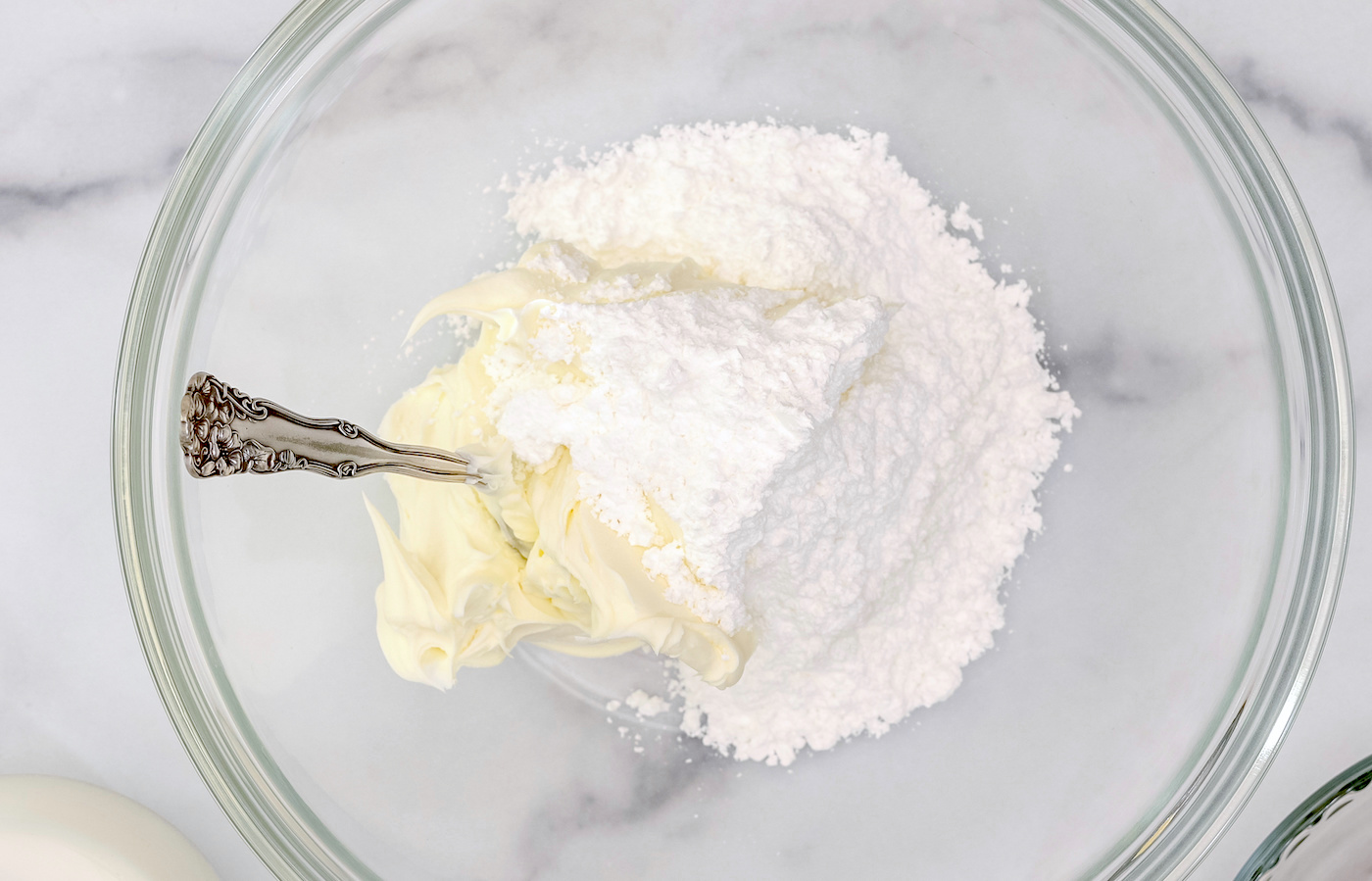 Cream cheese and powdered sugar close up in a glass bowl, flat lay, copy space. Whipped cream cheese desert recipe