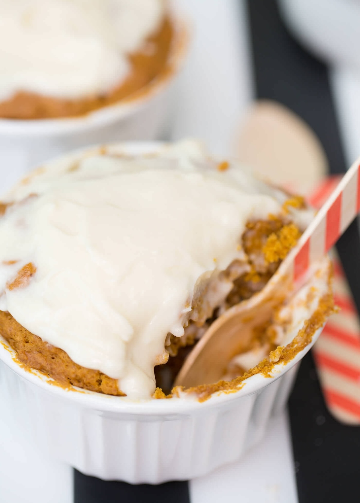 Pumpkin mug cake with frosting and a spoon in the dish