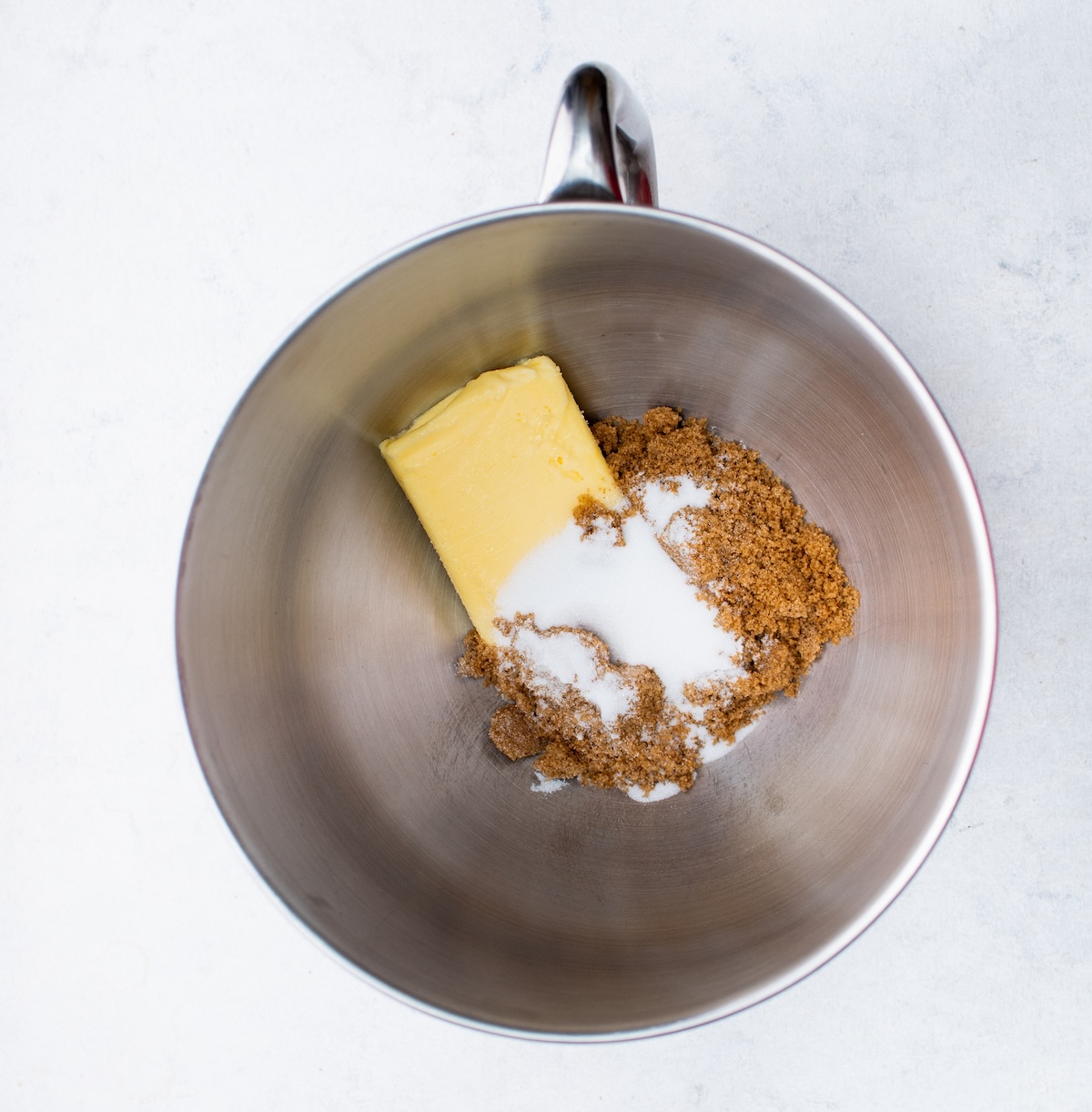 Butter and sugars in a metal bowl