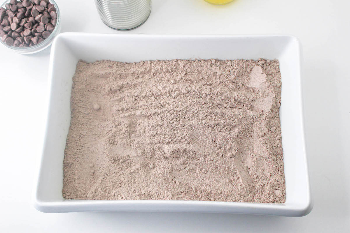 Chocolate cake mix poured out into the baking dish