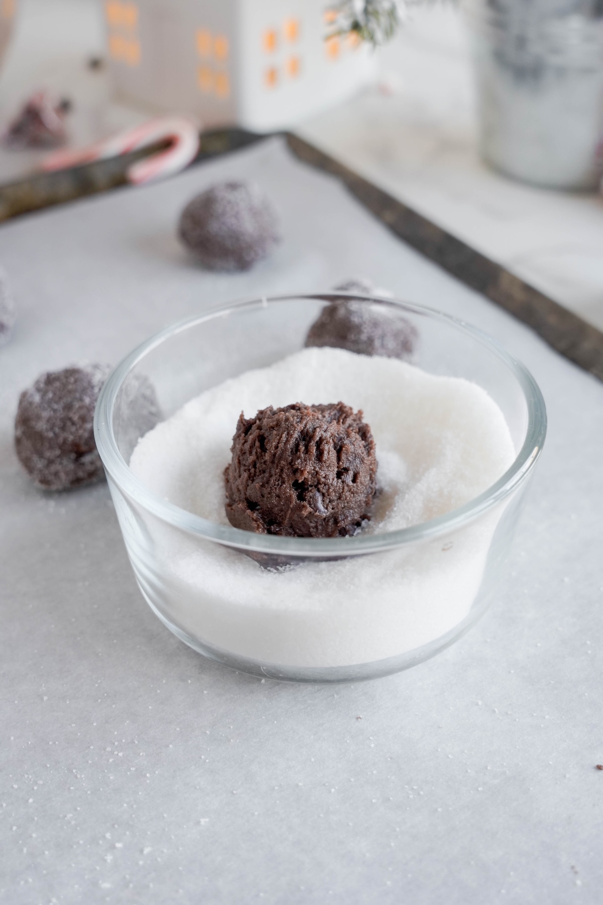 Cookie dough ball being rolled in sugar