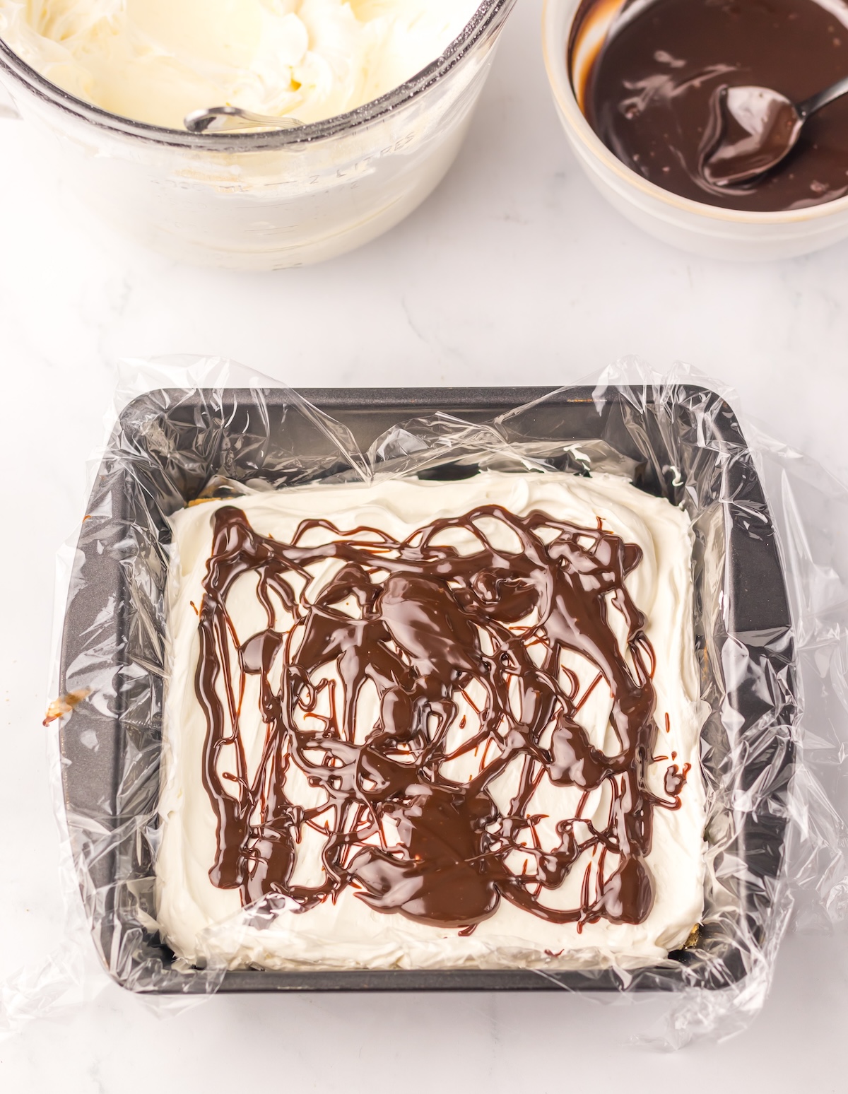 Marshmallow mixture and hot fudge added to the top of the graham crackers
