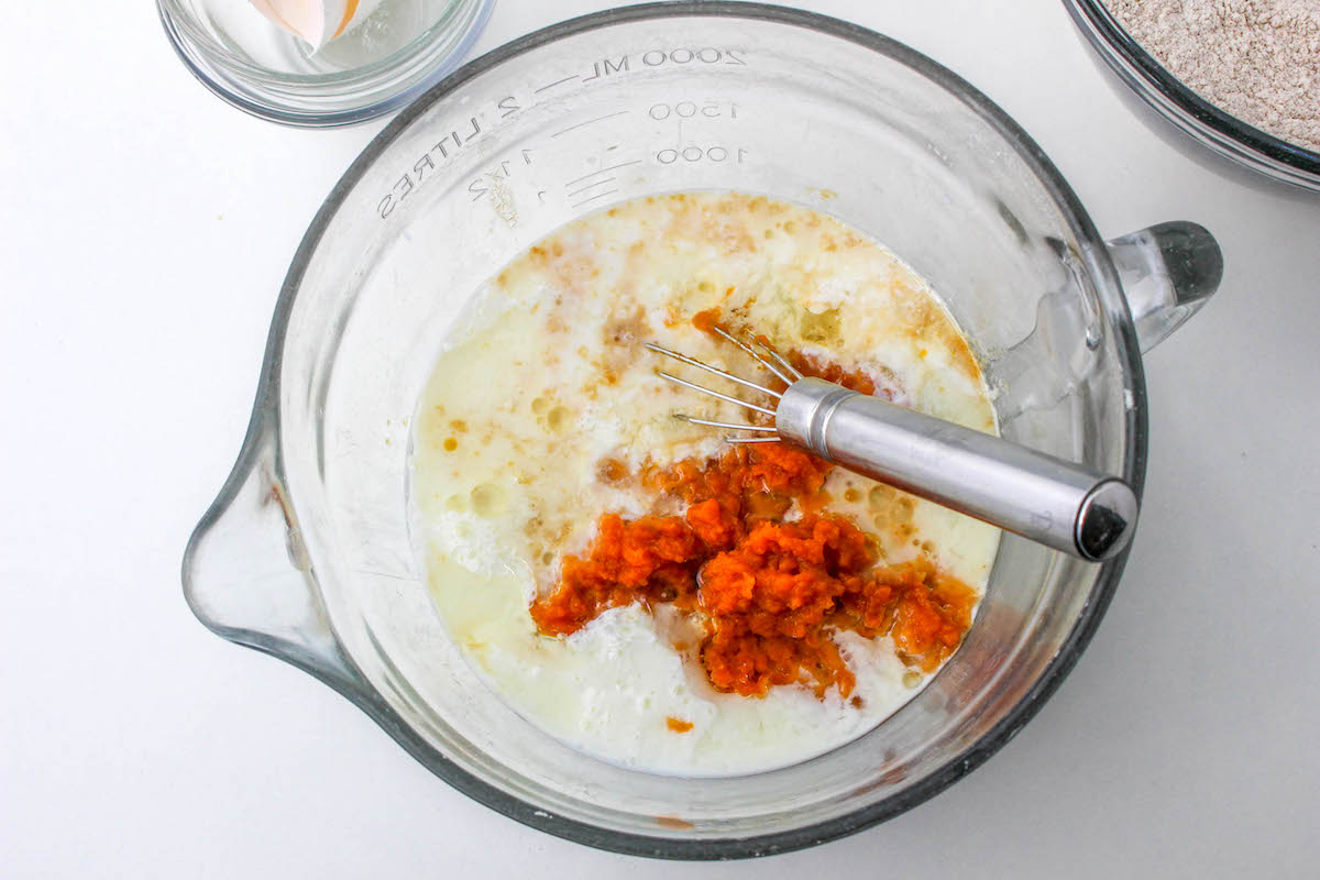 Milk, pumpkin, egg, oil, vinegar, and vanilla in a glass bowl