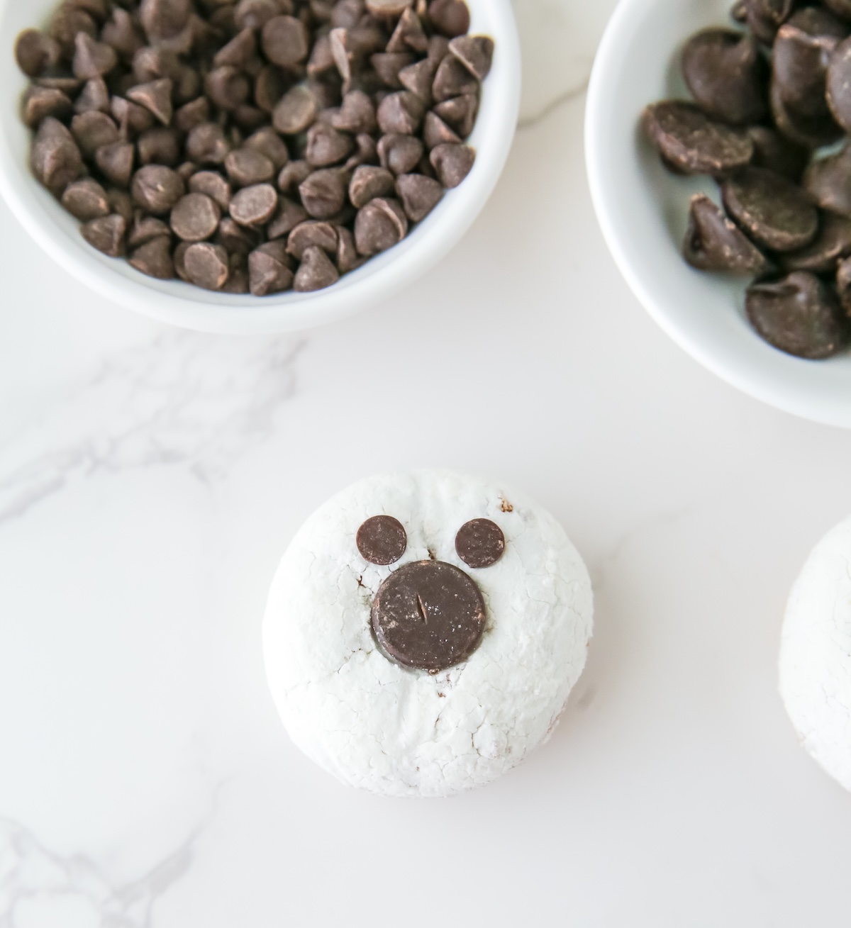 Placing one large chocolate chip for the mouth