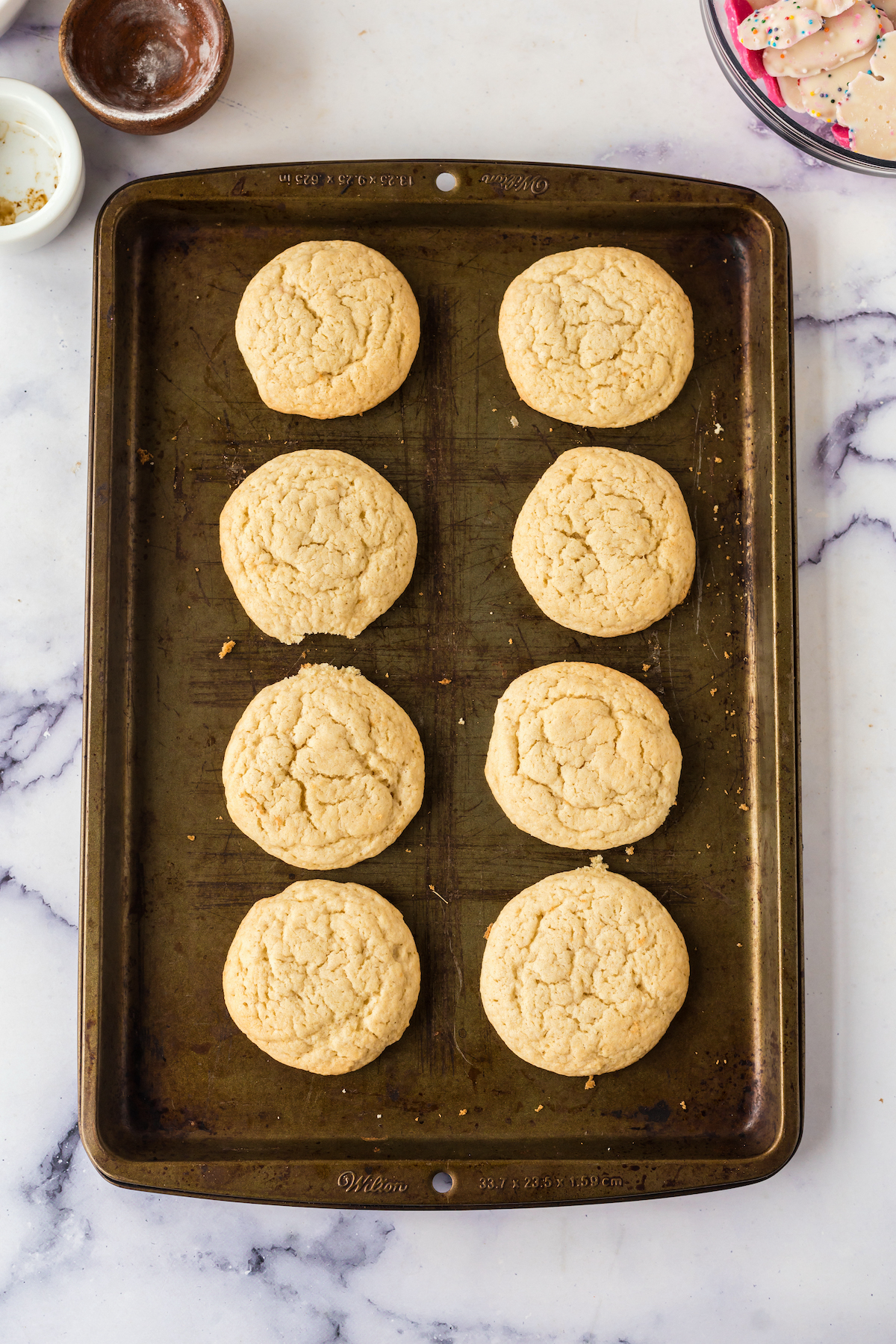 baked sugar cookies on the baking sheet cooling