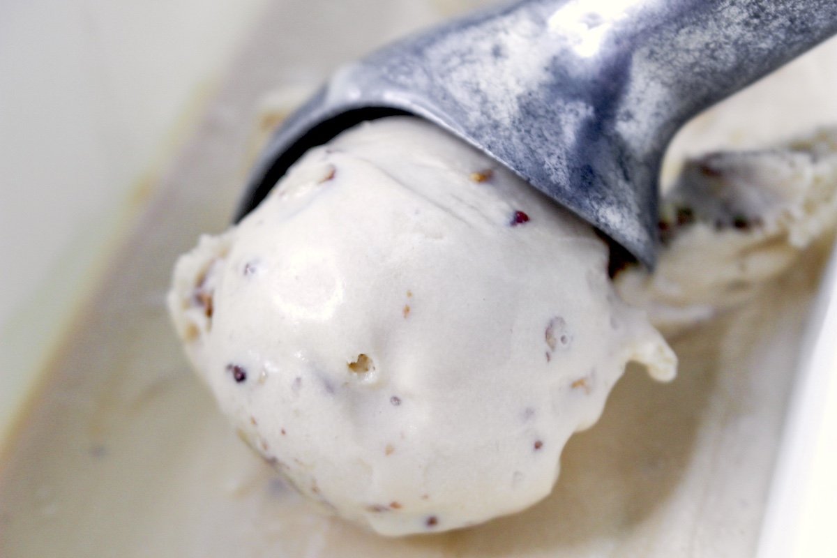 butter and pecan ice cream being scooped out of a container