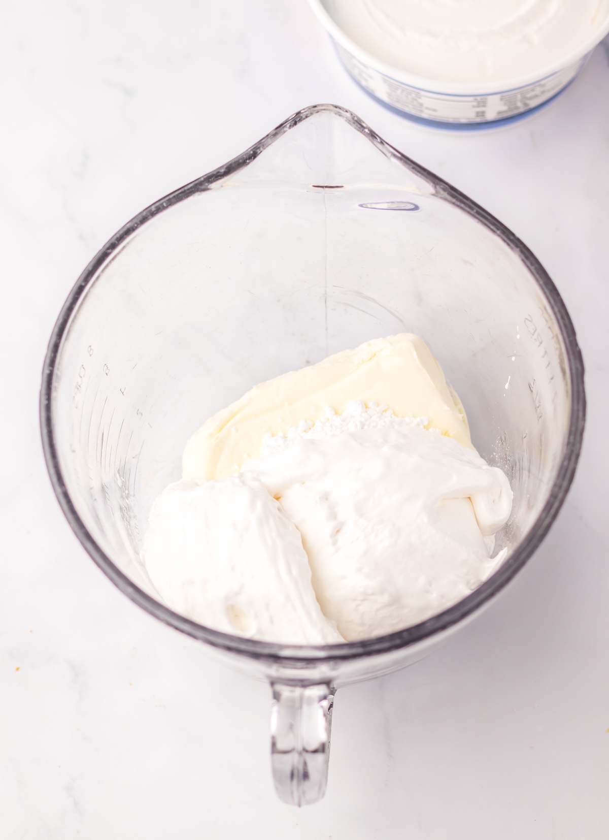 cream cheese, marshmallow cream, and powdered sugar in a glass bowl