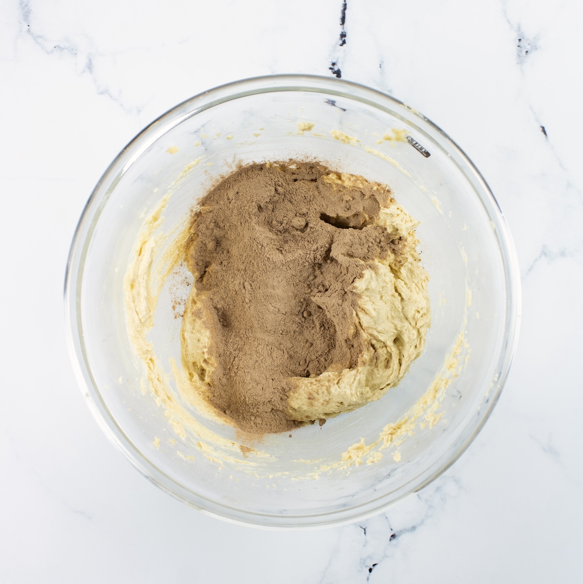 dry ingredients on top of the wet in a clear glass bowl