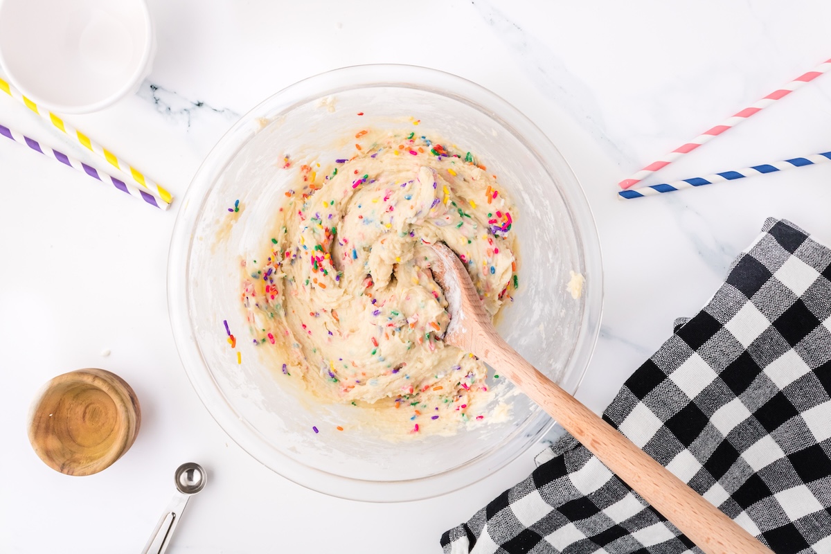 folding the sprinkles into the confetti cookie batter