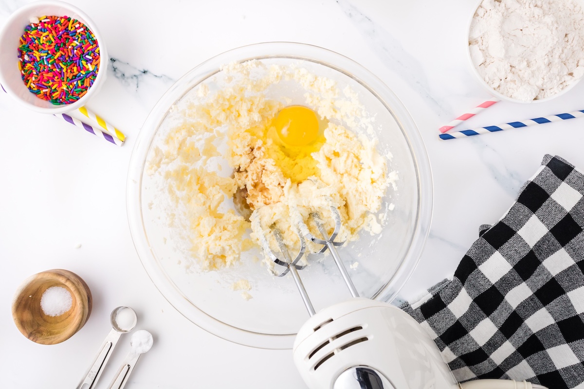 mixing the egg and vanilla into the batter with a white electric mixer