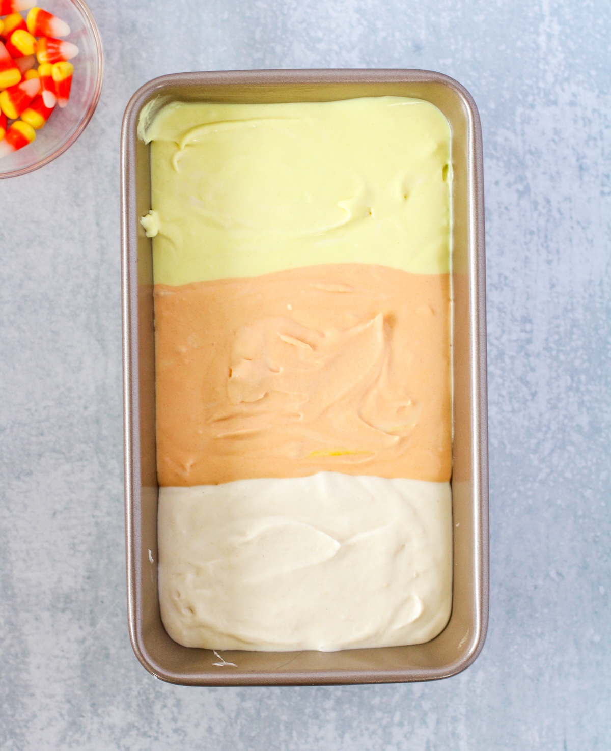 yellow, orange, and white ice cream in a metal pan