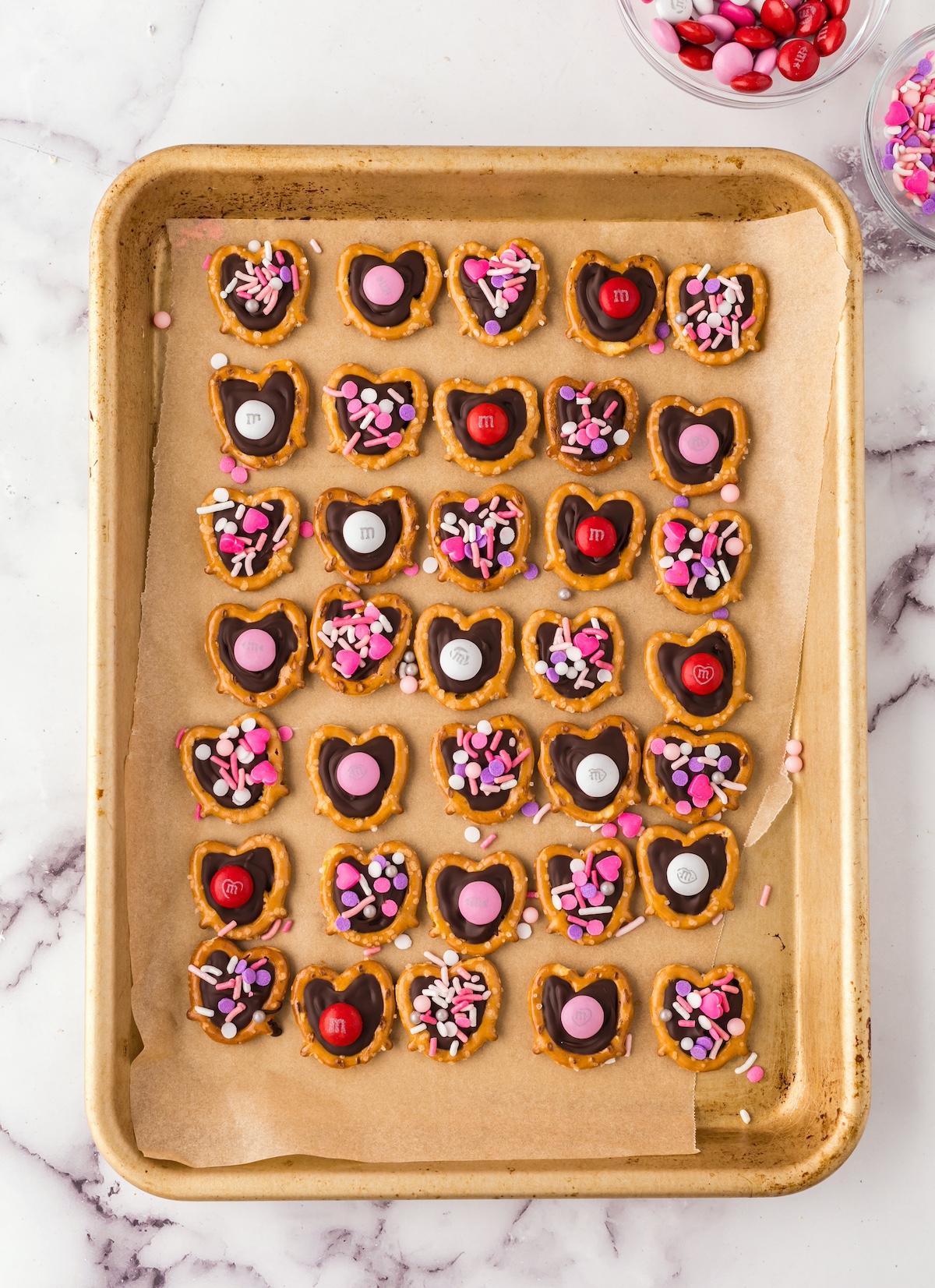 Pretzels laid on on a baking sheet with chocolate applied