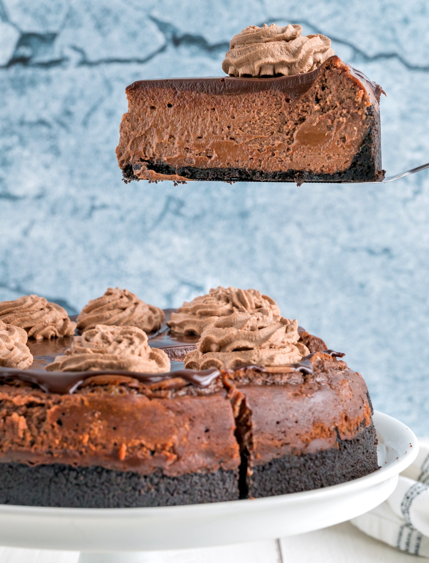 cutting a piece out of a chocolate cheesecake