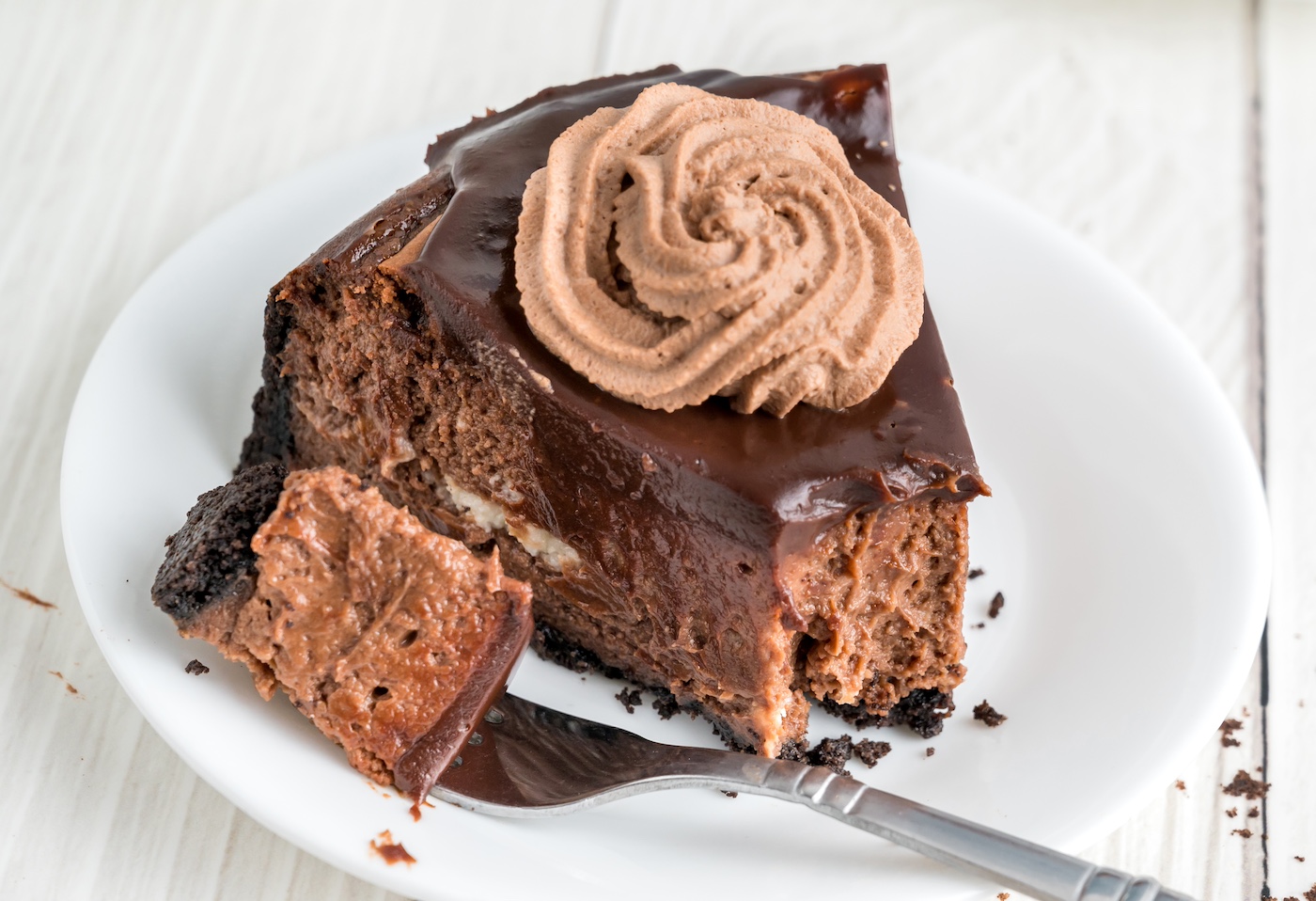 fork cutting a piece of chocolate cheesecake