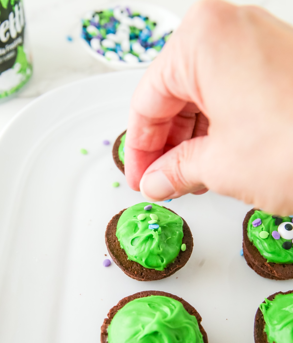 sprinkling sprinkles onto the brownie bites