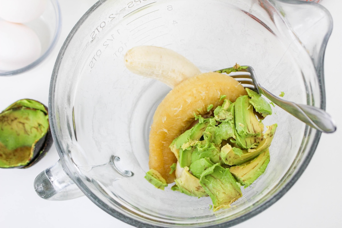 Banana and avocado mashed together in a glass bowl