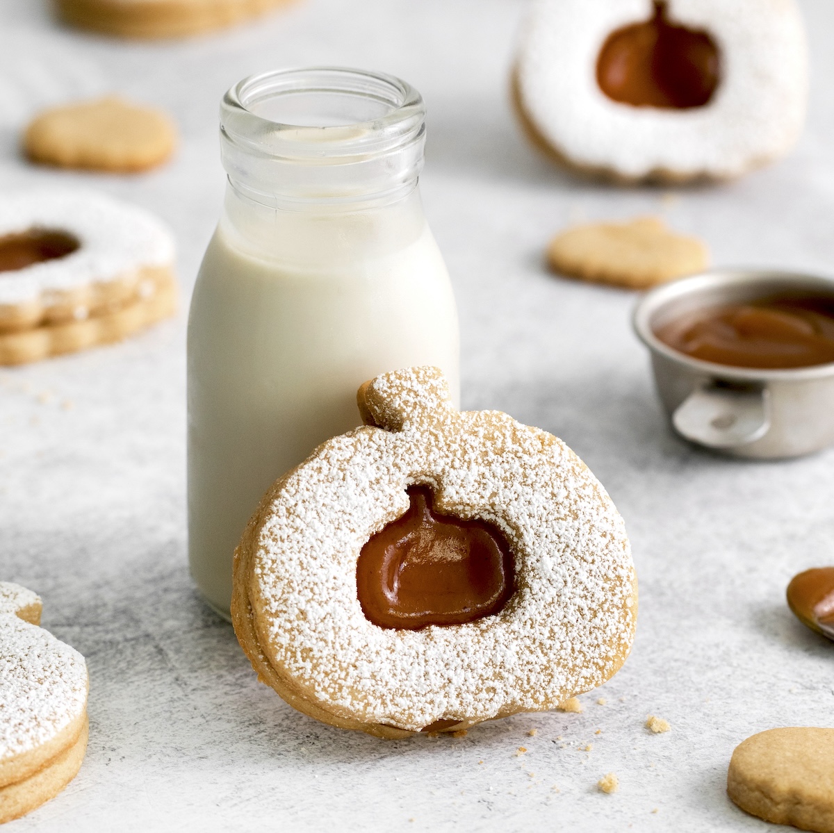 pumpkin linzer tart cookies with a bottle of milk