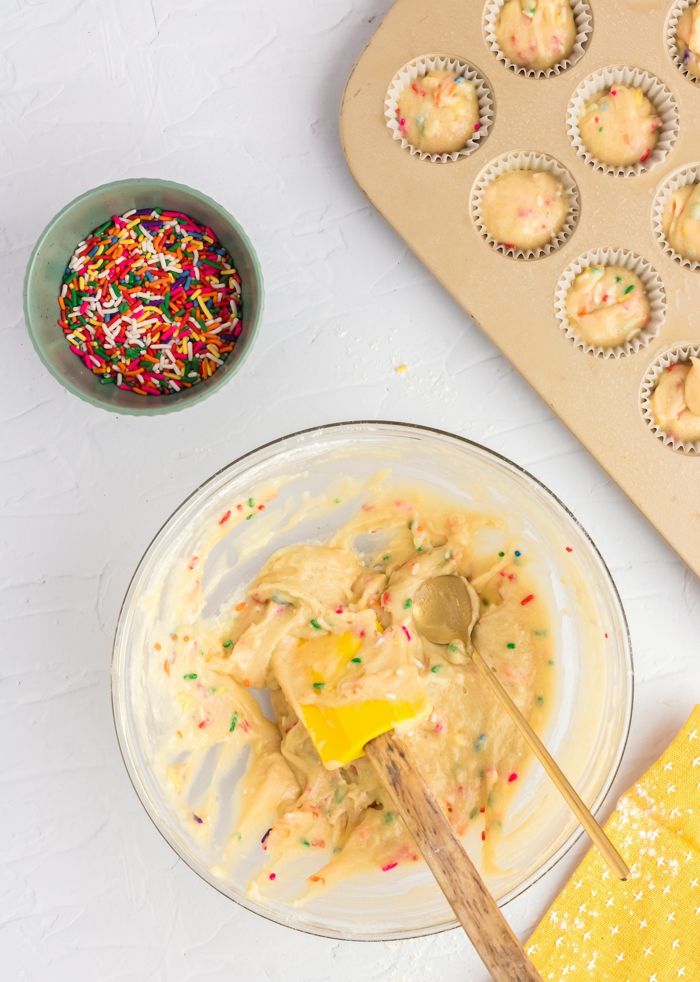 Adding funfetti batter to a muffin tin